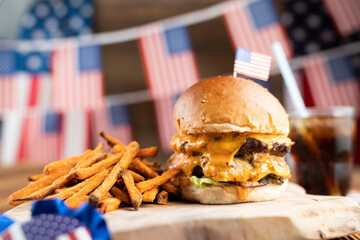 Fourth of July celebration. American flag and decorations. Burgers on rustic wooden table.