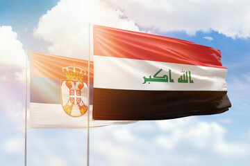 Sunny blue sky and flags of iraq and serbia