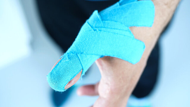Man showing kinesiology taping on his thumb