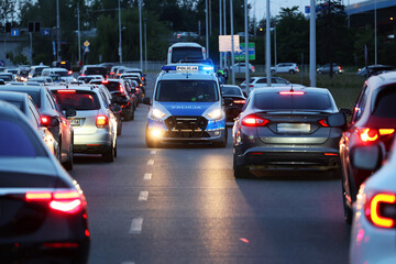 Radiowóz polskiej policji drogowej wieczorem w mieście podczas zabezpieczenia wypadku. - obrazy, fototapety, plakaty