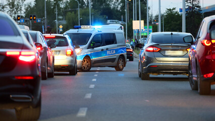 Radiowóz polskiej policji drogowej wieczorem w mieście podczas zabezpieczenia wypadku. - obrazy, fototapety, plakaty