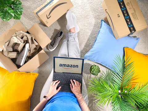 Germany, Rostock - Juni 13, 2022: Stack of Amazon Prime packages. woman shopping online at Amazon Prime Day. Distance, home and online shopping