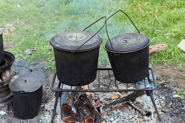 Hiking pot, Bowler in the bonfire. in cauldron at the stake. Traveling, tourism, picnic cooking,...