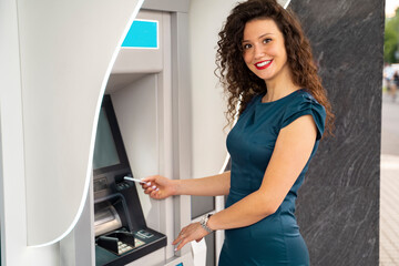 Fototapeta na wymiar Charming curly hair girl at ATM