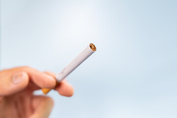 Hand holding a nicotine cigarette