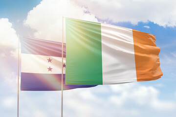 Sunny blue sky and flags of ireland and honduras