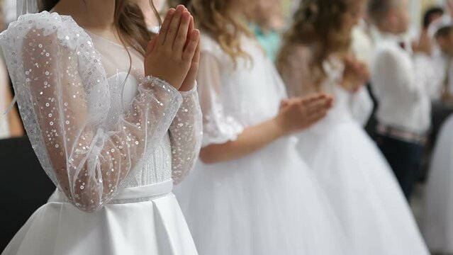 The first communion in the church for children. Children pray to God at the first communion.