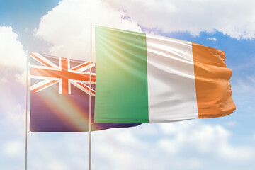 Sunny blue sky and flags of ireland and new zealand