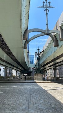 The curves and arcs of highway overhead the Nihonbashi bridge and the lamp post creates an interesting landscape.  Street of Tokyo Japan, year 2022 June 13th