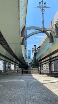 The curves and arcs of highway overhead the Nihonbashi bridge and the lamp post creates an interesting landscape.  Street of Tokyo Japan, year 2022 June 13th