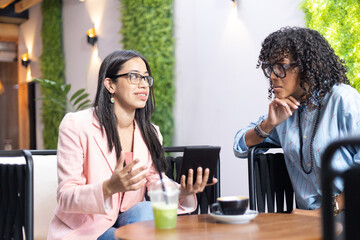 Woman with eyeglasses chatting with a friend at a coffeeshop