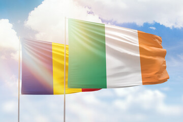Sunny blue sky and flags of ireland and romania
