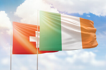 Sunny blue sky and flags of ireland and switzerland
