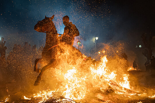 Horses With Their Riders Jumping Bonfires As A Tradition To Purify Animals..