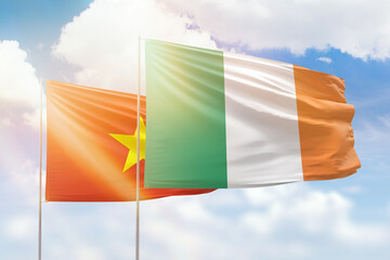 Sunny blue sky and flags of ireland and vietnam