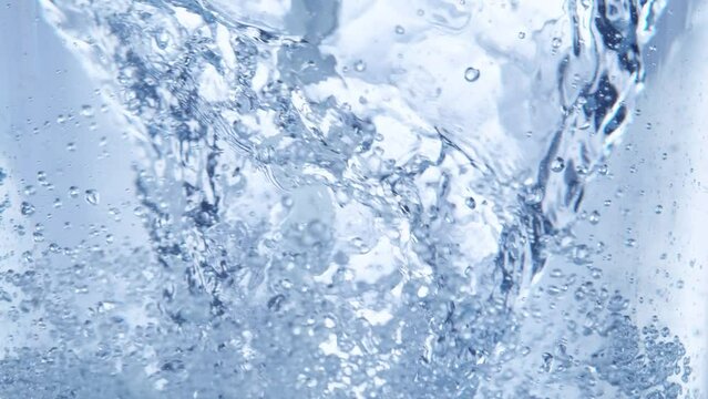 Super Slow Motion Shot of Water Whirl on Light Blue Background at 1000fps.