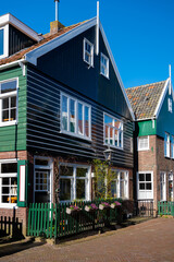Walking on sunny day in small Dutch town Marken with wooden houses located on former island in North Holland, Netherlands