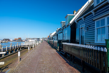 Fototapeta premium Walking on sunny day in small Dutch town Marken with wooden houses located on former island in North Holland, Netherlands