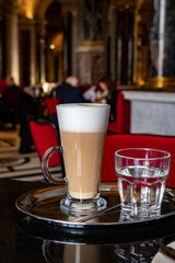 Glass cup of coffee latte served in classic old Austrian café-restaurant in Vienna