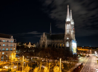 Obraz premium Capital of Austria Vienna at night, view on gothic church and streets of the city