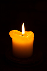 One burning candle in dark underground shelter
