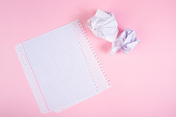 Blank paper and crumpled paper wads on pink background. Search for inspiration, writing plans.