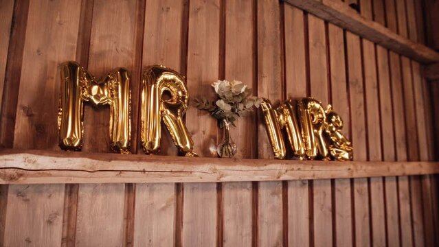 Golden Balloons in the Shape of Letters Placed on the Wall. Wedding Decoration.