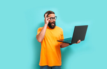 Young crazy bearded charismatic man. Shocked or surprised expression. Laptop concept. Funny...