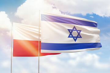 Sunny blue sky and flags of israel and poland