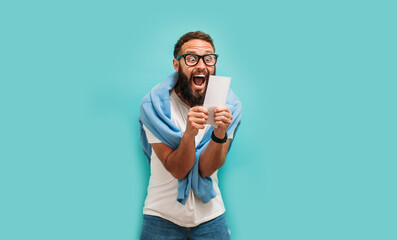 Excited happy young male winner feeling joy winning lottery, placing bets, getting cashback online...