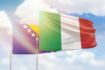 Sunny blue sky and flags of italy and bosnia
