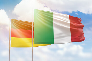 Sunny blue sky and flags of italy and germany