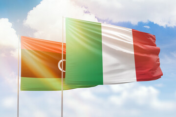 Sunny blue sky and flags of italy and libya
