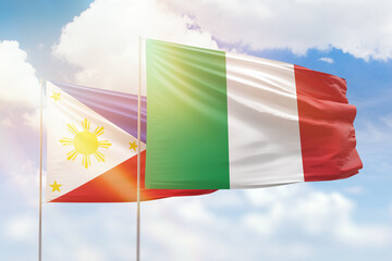 Sunny blue sky and flags of italy and philippines