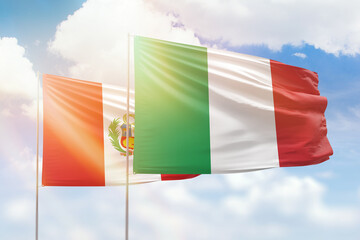Sunny blue sky and flags of italy and peru