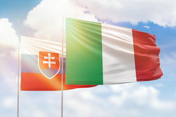 Sunny blue sky and flags of italy and slovakia