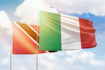 Sunny blue sky and flags of italy and trinidad and tobago