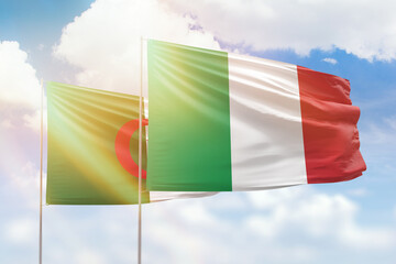 Sunny blue sky and flags of italy and algeria