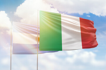 Sunny blue sky and flags of italy and argentina