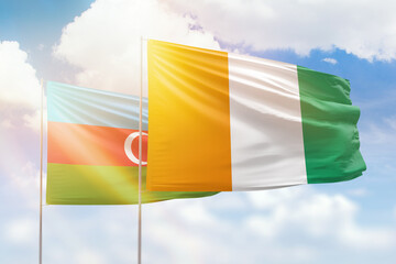 Sunny blue sky and flags of ivory coast and azerbaijan