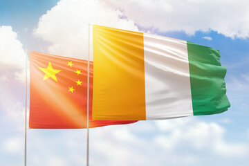 Sunny blue sky and flags of ivory coast and china