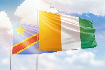 Sunny blue sky and flags of ivory coast and dr congo