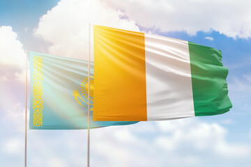 Sunny blue sky and flags of ivory coast and kazakhstan