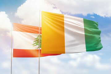 Sunny blue sky and flags of ivory coast and lebanon