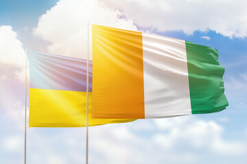 Sunny blue sky and flags of ivory coast and ukraine