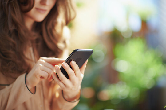 Elegant woman at home in sunny day using phone applications