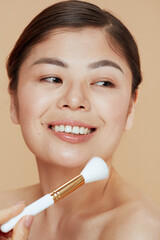 young asian woman with makeup brush