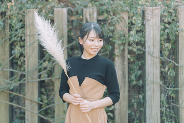 愛知県名古屋市の庭園を散策する若い女性 Young woman strolling through a garden in...