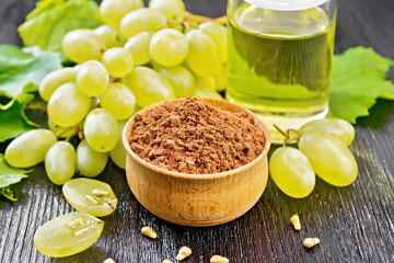 Flour grape seed in bowl on dark board