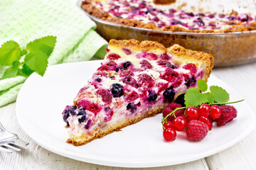 Pie with raspberries and currants in plate on white board
